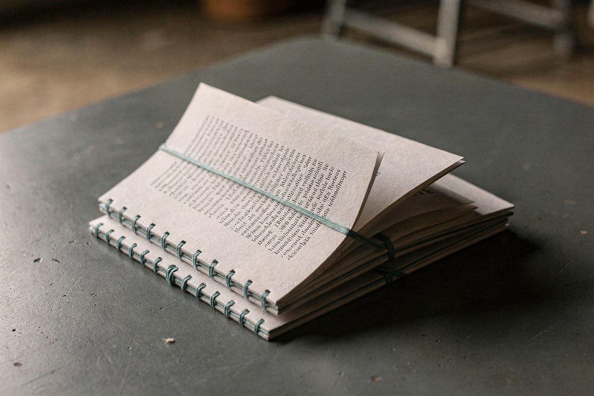 A stack of small printed tone-of-voice guide booklets on a slate table.